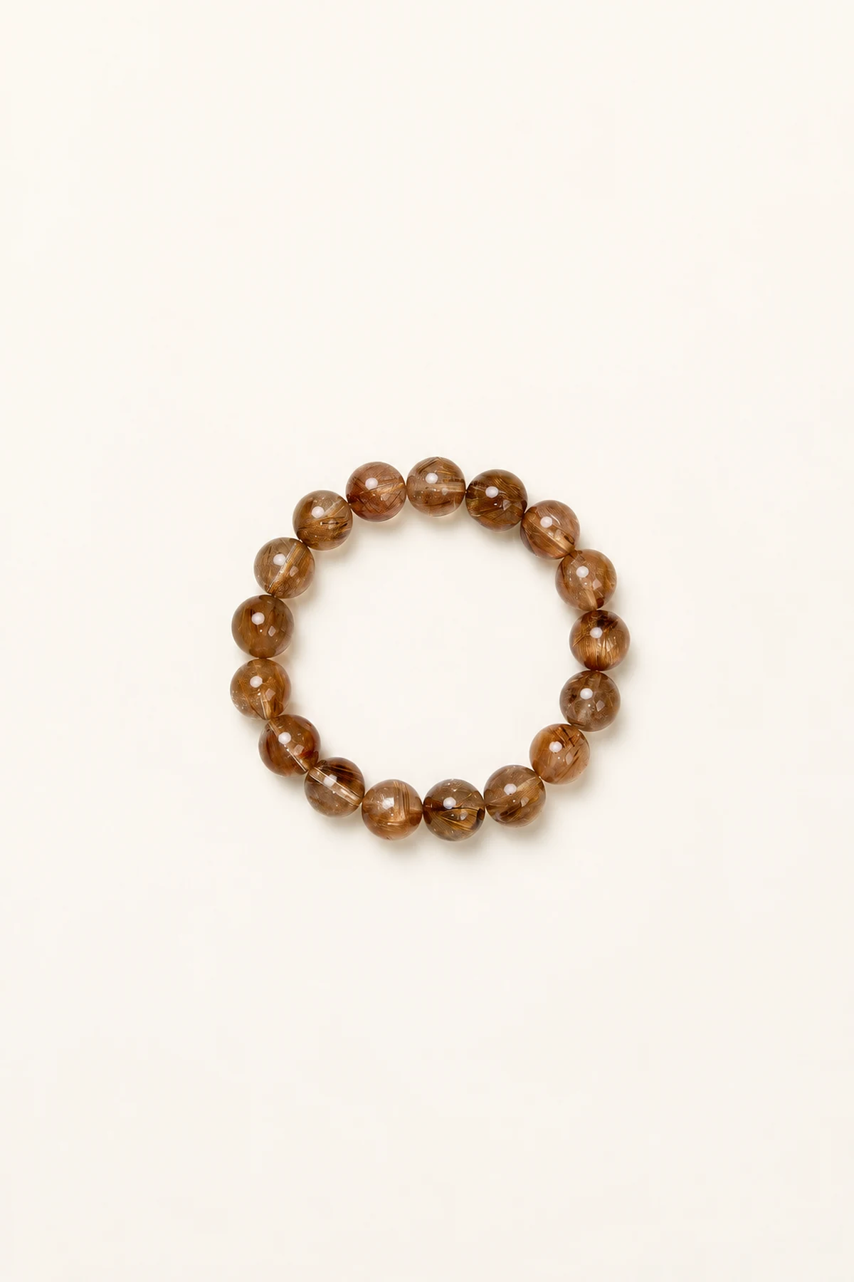 Copper-toned rutilated quartz bead bracelet on a pale surface